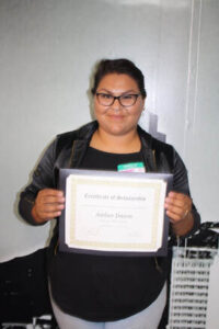 Amber Duron, Education is Forever scholarship recipient, proudly holds her Certificate of Scholarship, celebrating her academic achievement and commitment to continuing her education.