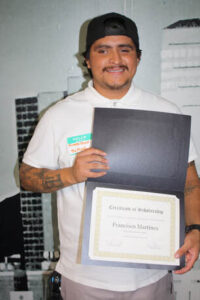 Francisco Martines, former Education is Forever scholarship recipient, proudly displays his Certificate of Scholarship, celebrating his educational achievements and commitment to building a brighter future.